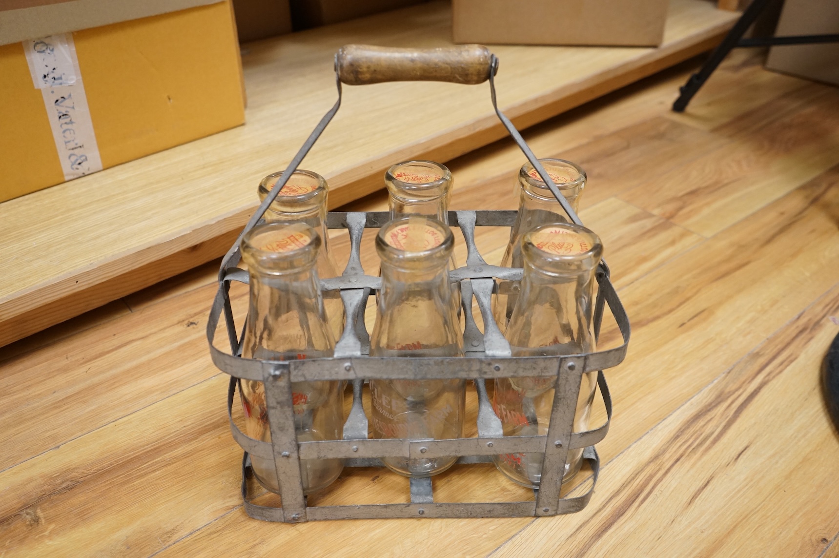 A vintage metal crate of six H J Lee, Horsham milk bottles